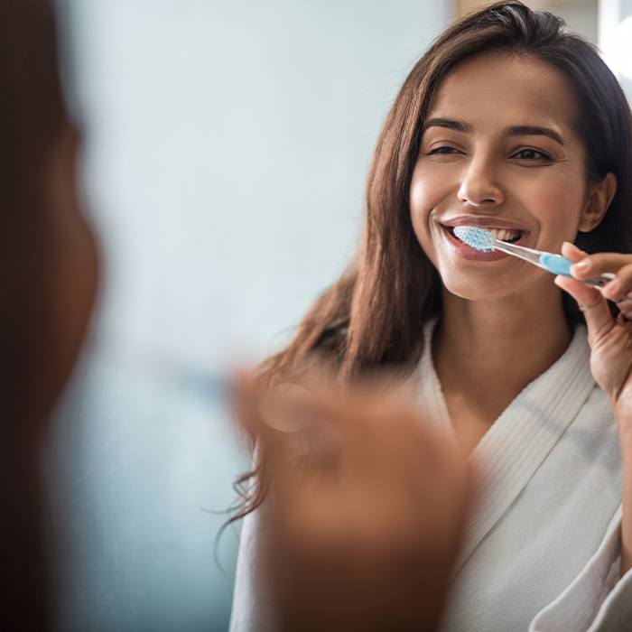 Woman using at home at home oral hygiene products