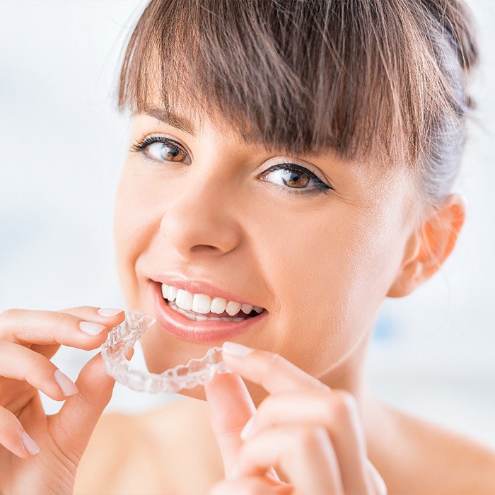Woman placing an Invisalign tray