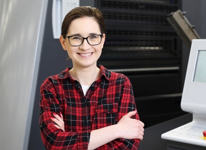 Woman with glasses and red flannel shirt smiling