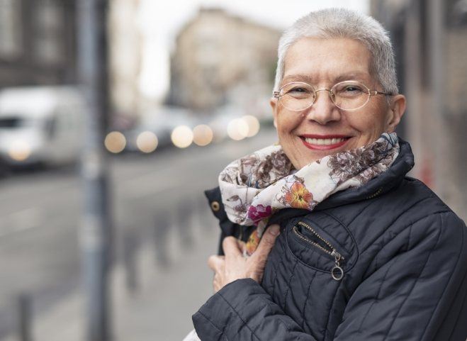 Smiling woman with glasses scarf and jacket