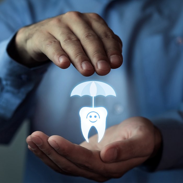 Hands holding an animated tooth under an umbrella