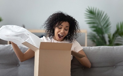 woman excitedly opening a package