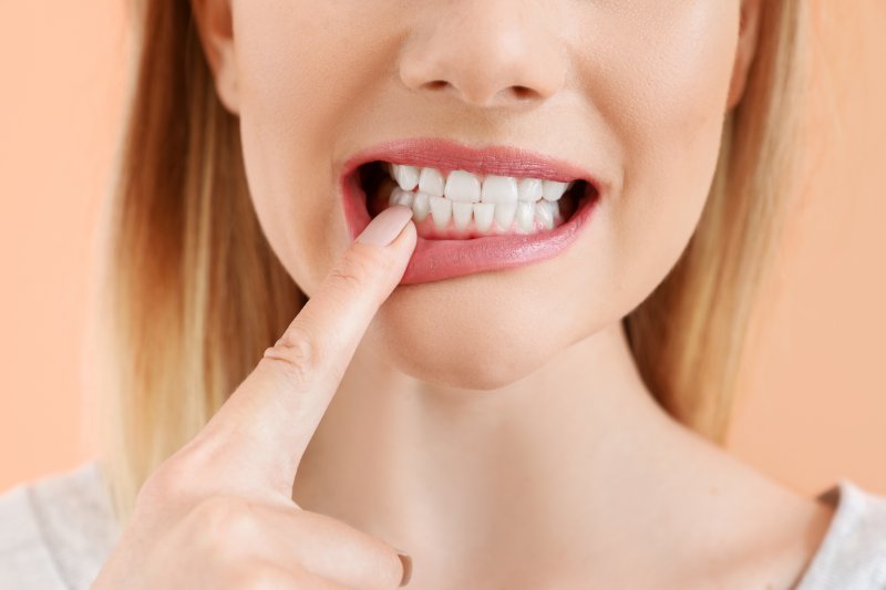 closeup of woman pointing at her teeth
