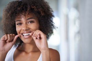woman flossing for a healthy smile 